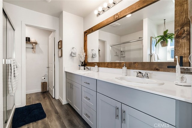 bathroom featuring walk in shower, wood-type flooring, and vanity