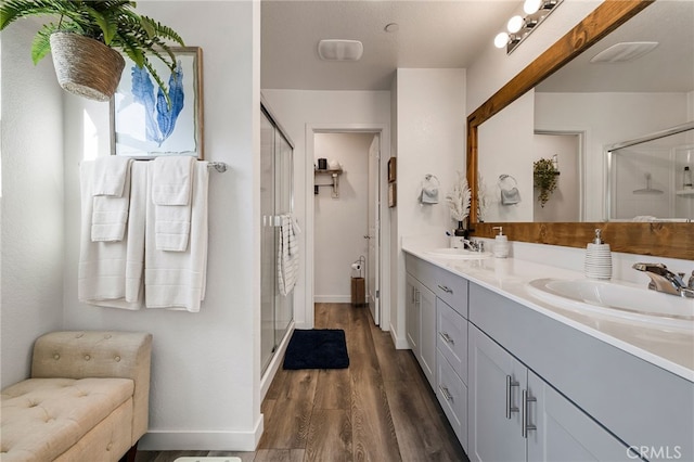 bathroom with a shower with door, vanity, and hardwood / wood-style floors