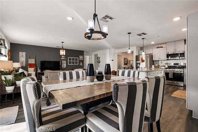 dining space with an inviting chandelier and dark hardwood / wood-style floors