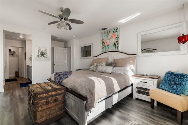 bedroom with dark wood-type flooring, ceiling fan, and connected bathroom