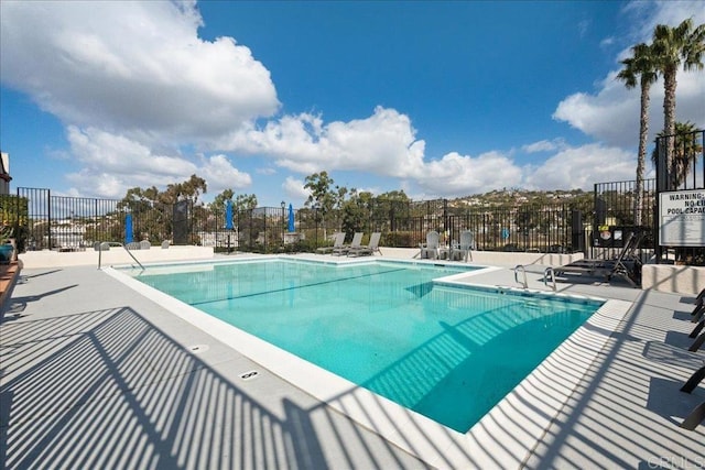 community pool featuring a patio area and fence