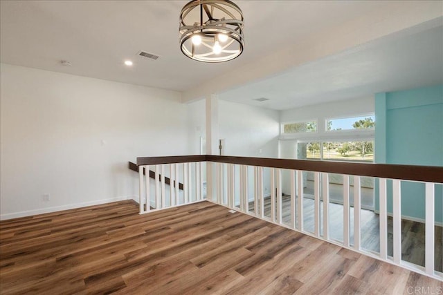 spare room featuring a notable chandelier, recessed lighting, visible vents, wood finished floors, and baseboards