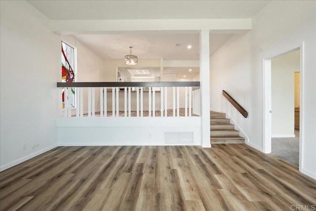 spare room with baseboards, stairs, visible vents, and wood finished floors