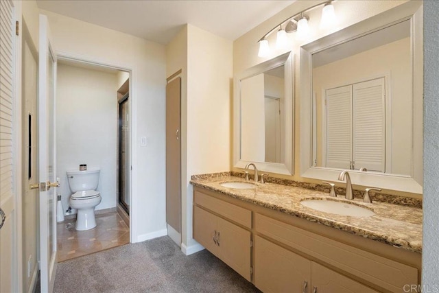 bathroom with a closet, a sink, toilet, and double vanity