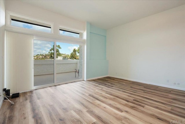 empty room with baseboards and light wood finished floors