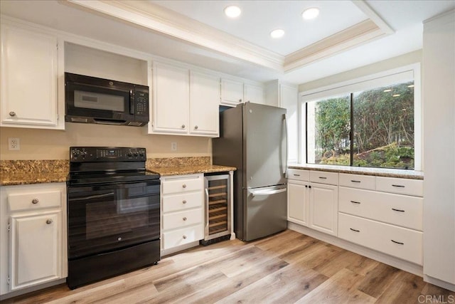 kitchen featuring wine cooler, a raised ceiling, white cabinetry, and black appliances