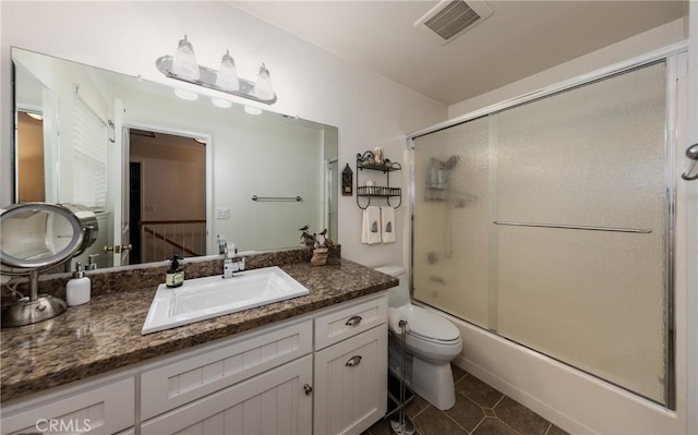 full bathroom featuring enclosed tub / shower combo, vanity, toilet, and tile patterned flooring