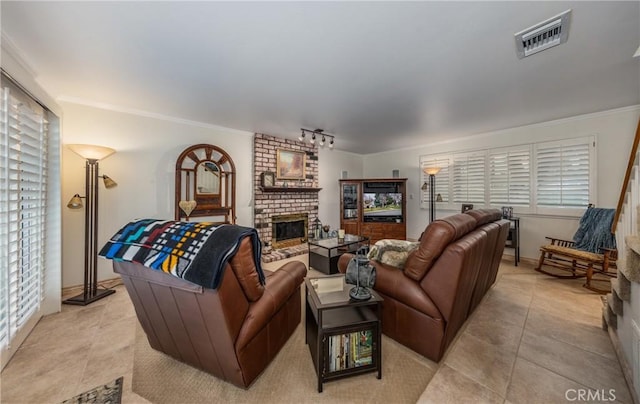 living room featuring light tile patterned floors, a fireplace, ornamental molding, and track lighting