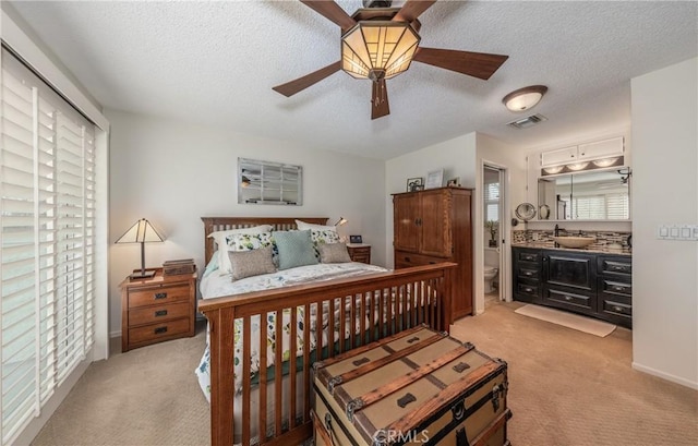 bedroom with light carpet, ceiling fan, multiple windows, and a textured ceiling