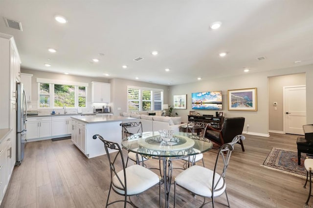 dining area with sink and light wood-type flooring