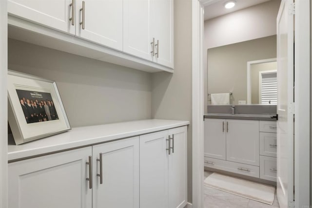 interior space with white cabinetry and sink