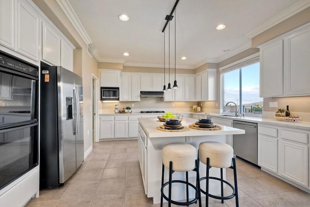 kitchen with white cabinetry, pendant lighting, black appliances, and a center island