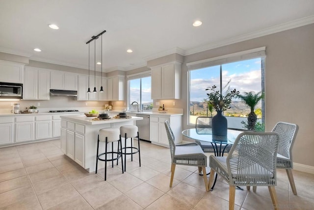 kitchen with a kitchen island, pendant lighting, white cabinetry, stainless steel appliances, and crown molding