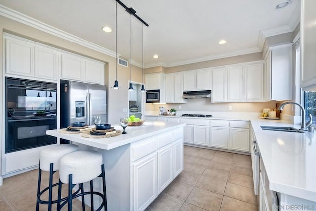 kitchen featuring sink, light tile patterned floors, stainless steel appliances, a center island, and white cabinets