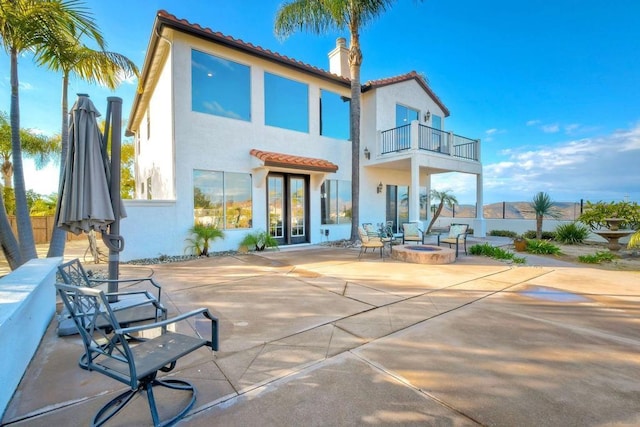 rear view of house with a patio area and a balcony