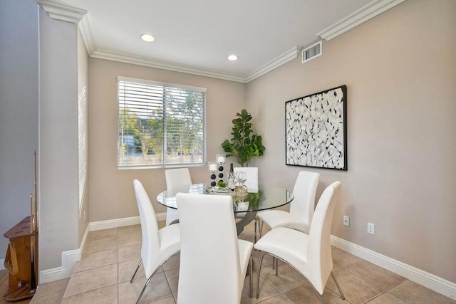 dining space featuring ornamental molding and light tile patterned flooring