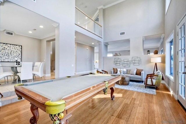 rec room featuring crown molding, a towering ceiling, pool table, and light wood-type flooring