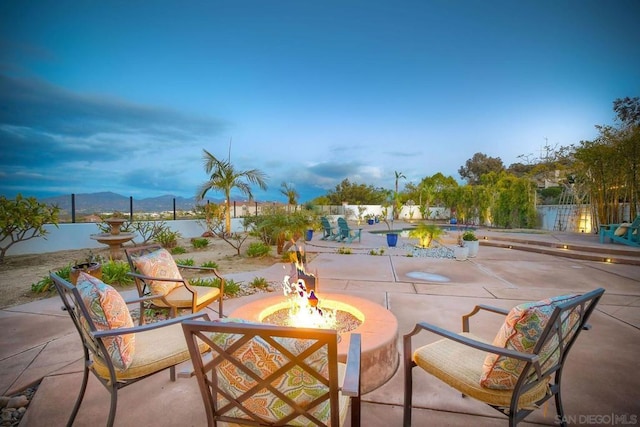 patio terrace at dusk with a mountain view and an outdoor fire pit