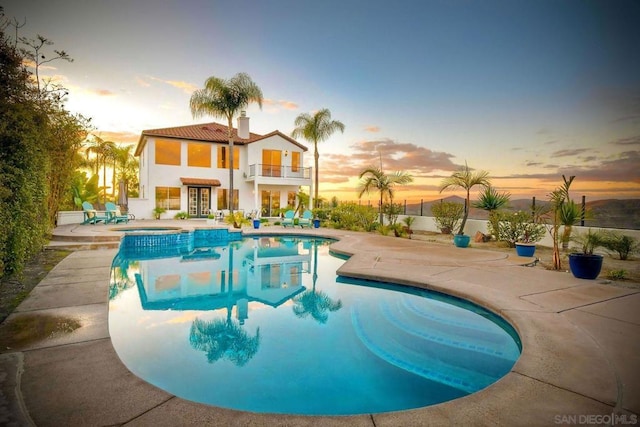 pool at dusk with a patio