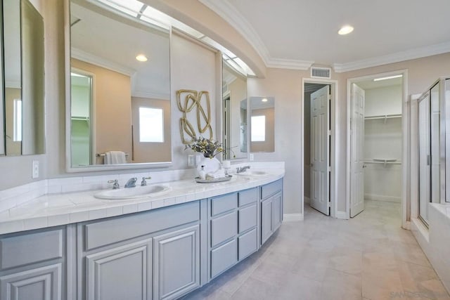 bathroom featuring a shower with door, ornamental molding, and vanity