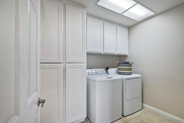 laundry room featuring cabinets, washer and dryer, and light tile patterned floors