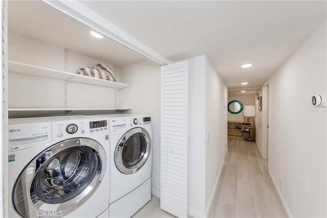 laundry room with washer and dryer and light hardwood / wood-style floors