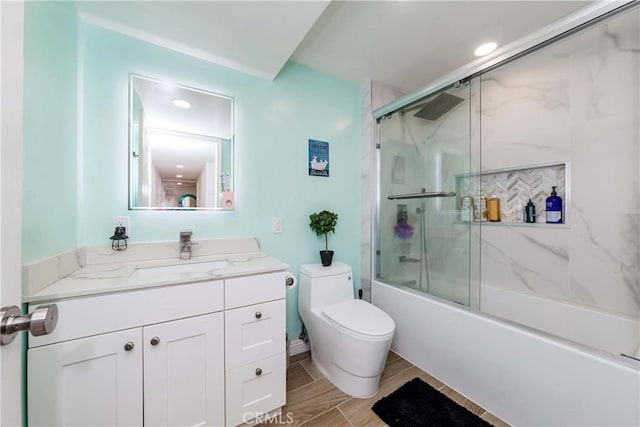 full bathroom with shower / bath combination with glass door, vanity, and toilet