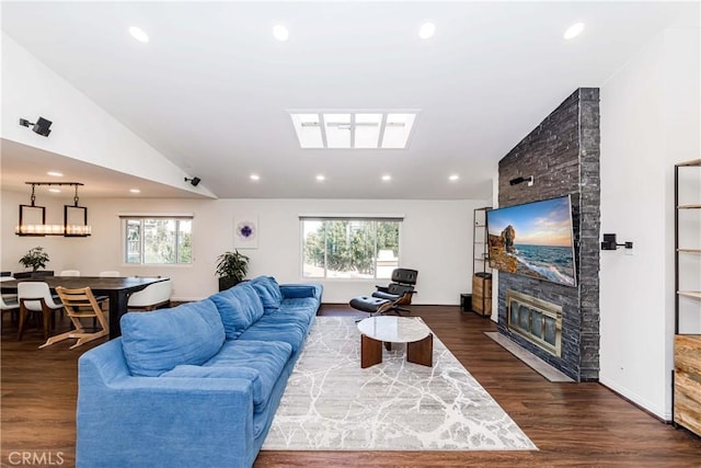 living room with lofted ceiling, dark hardwood / wood-style floors, and a large fireplace