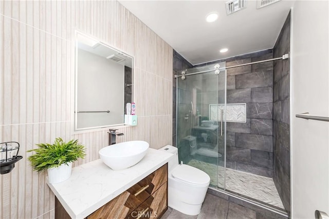 bathroom with a shower with door, vanity, and toilet