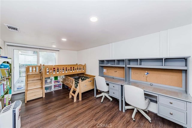 home office featuring dark hardwood / wood-style floors and built in desk