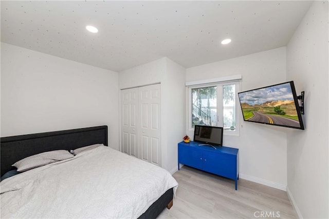 bedroom with light wood-type flooring and a closet