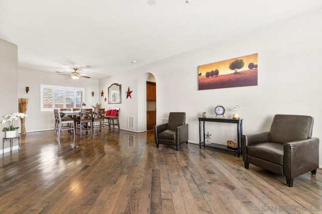 living area with ceiling fan and dark hardwood / wood-style floors