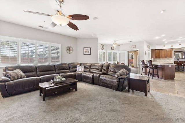 carpeted living room with ceiling fan