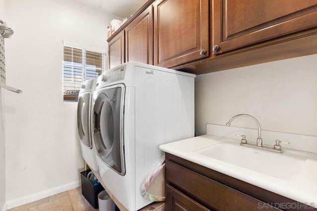 laundry area featuring cabinets, washing machine and dryer, sink, and light tile patterned floors