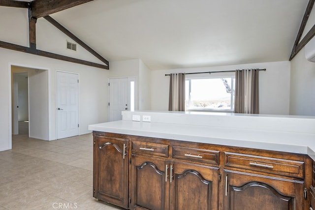 kitchen featuring light tile patterned flooring, dark brown cabinets, and vaulted ceiling with beams