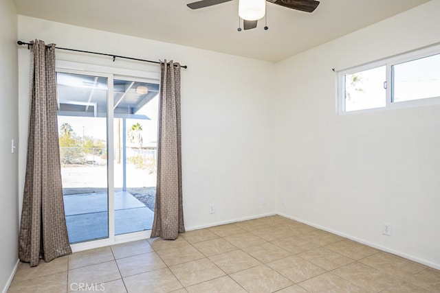 tiled spare room featuring ceiling fan