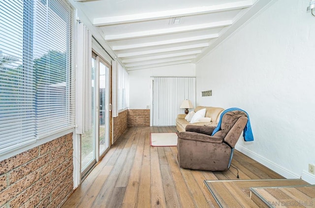 sitting room with hardwood / wood-style flooring and vaulted ceiling with beams