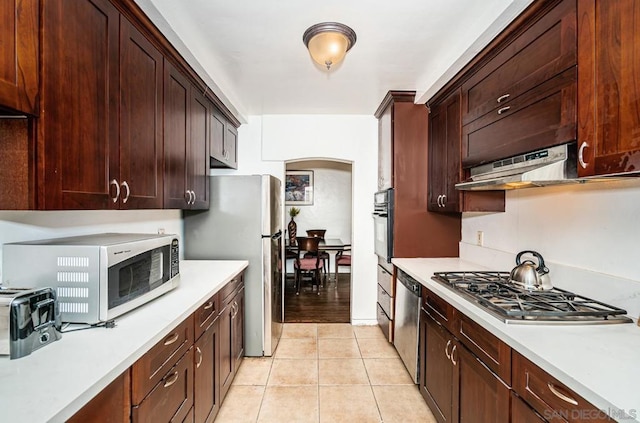 kitchen featuring stainless steel appliances and light tile patterned flooring