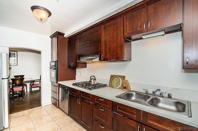 kitchen with appliances with stainless steel finishes, sink, and light tile patterned floors