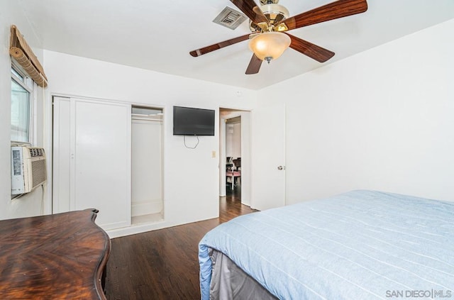 bedroom featuring dark wood-type flooring, cooling unit, ceiling fan, and a closet