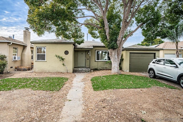 single story home featuring cooling unit and a garage