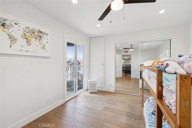 bedroom featuring ceiling fan, access to exterior, a closet, and light wood-type flooring