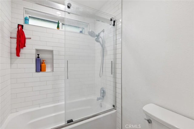 bathroom featuring enclosed tub / shower combo and toilet