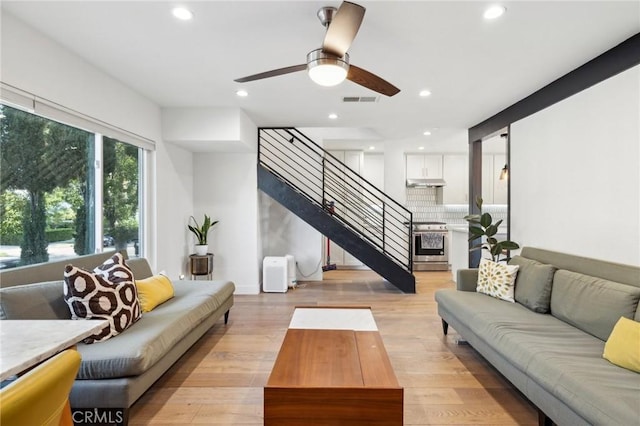 living room with ceiling fan and light wood-type flooring