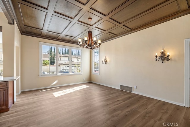 unfurnished dining area featuring crown molding, coffered ceiling, a notable chandelier, and light hardwood / wood-style flooring