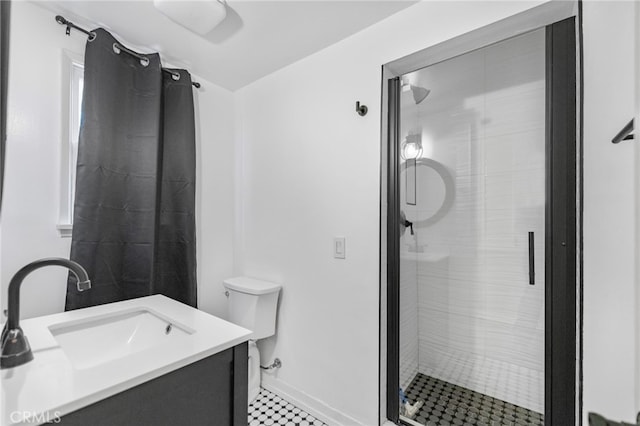 bathroom with vanity, a shower with door, and toilet