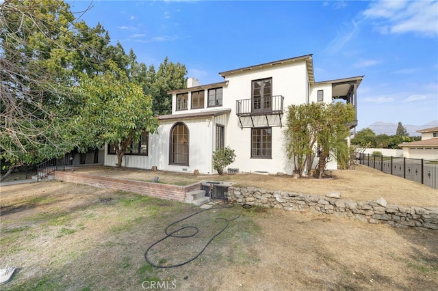 back of house featuring a balcony and a mountain view