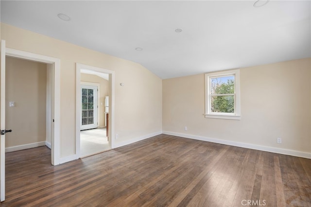 unfurnished room featuring lofted ceiling and dark hardwood / wood-style flooring