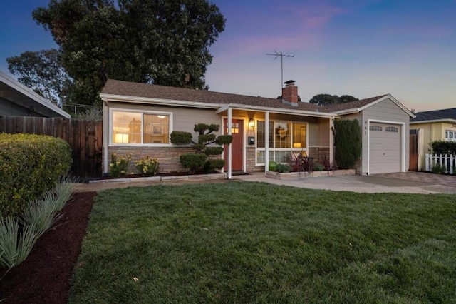 single story home featuring a porch, a garage, and a lawn