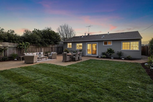 back house at dusk with a lawn, outdoor lounge area, and a patio